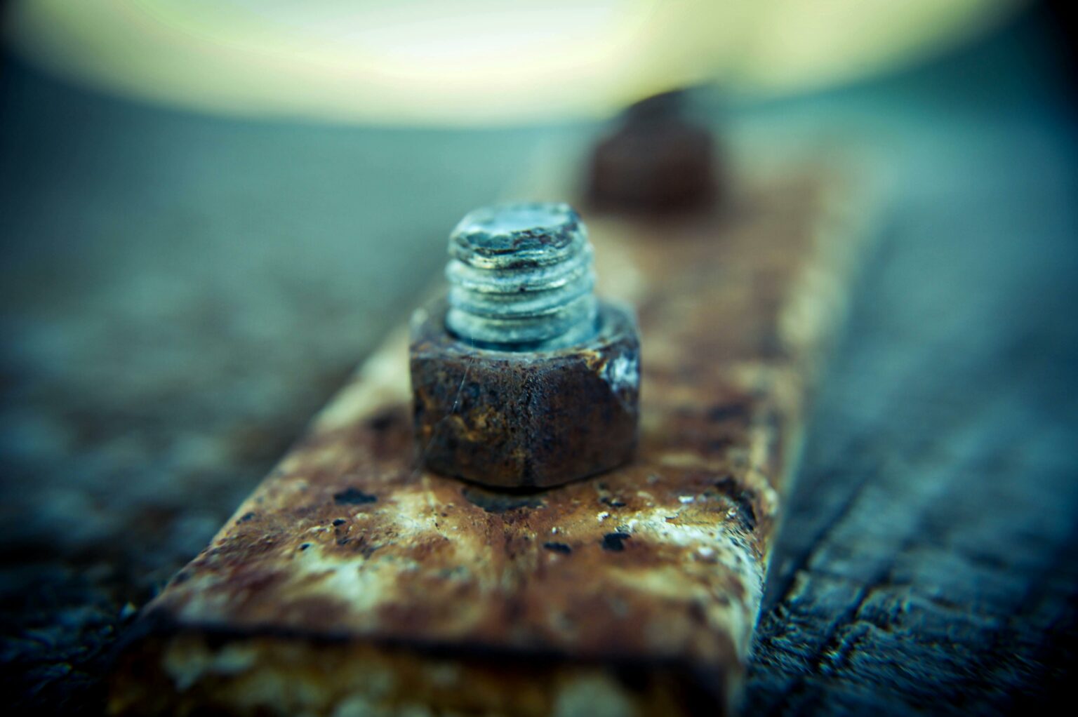 Detailed macro image of a rusty screw on a metal plate showcasing natural decay and texture.