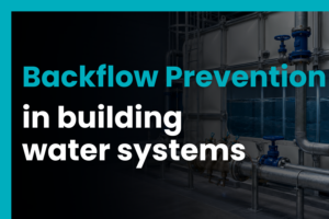 Backflow prevention device and pipework connected to a GRP cold water storage tank in a plant room, representing water quality protection and building water system compliance.